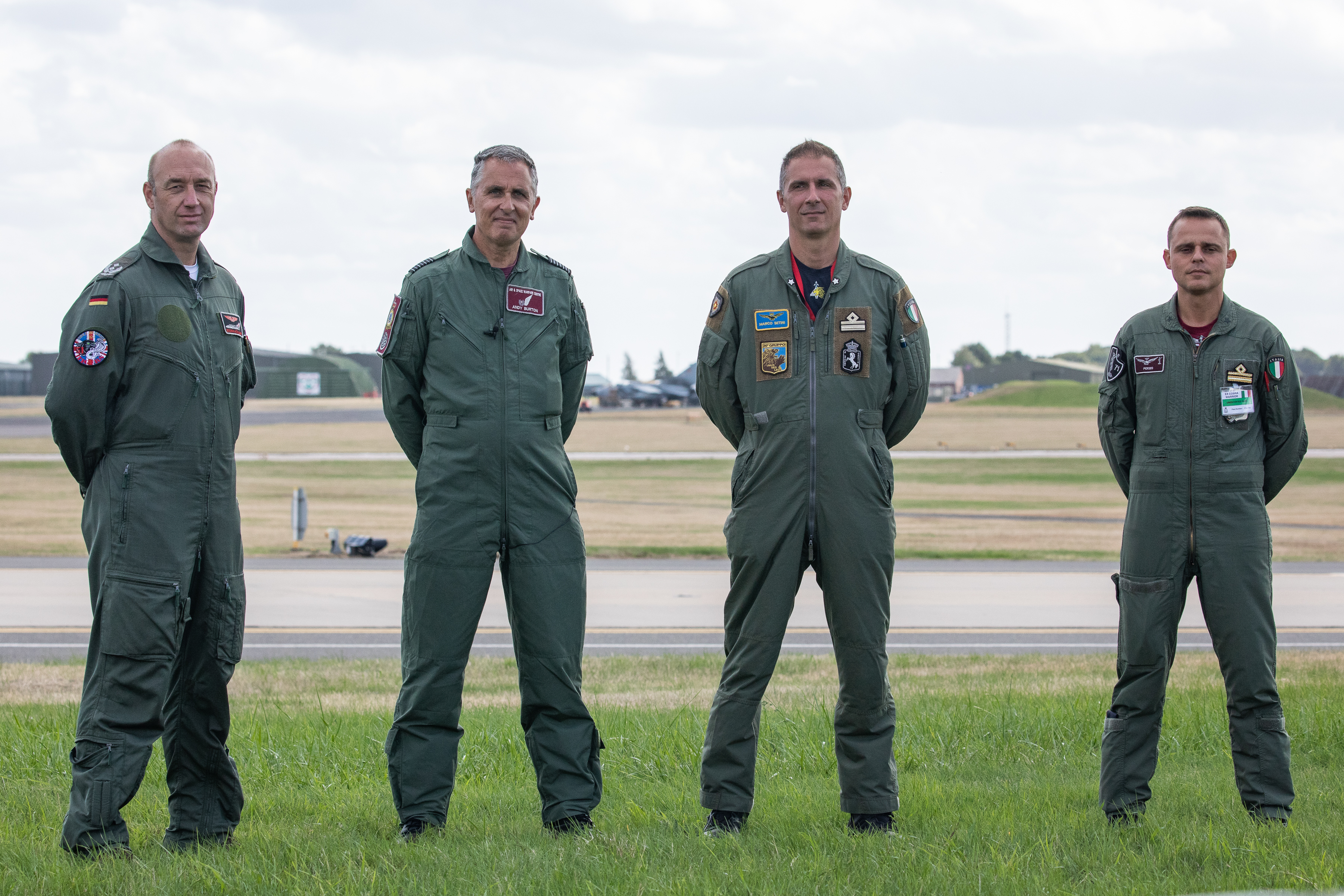 Image shows personnel standing in a line on the airfield.